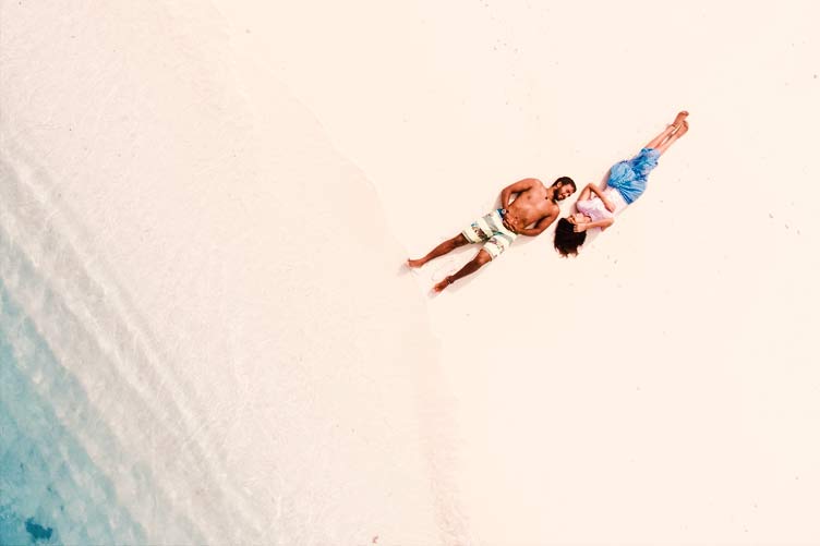 Honeymoon couple sunbathing at Bora Bora beach